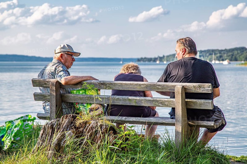 Two men and a woman on a park bench