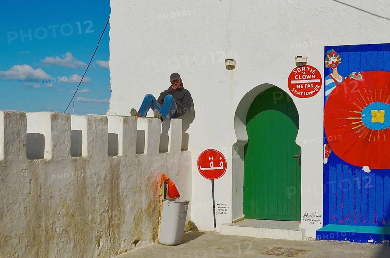 Young man sunbathing on city wall