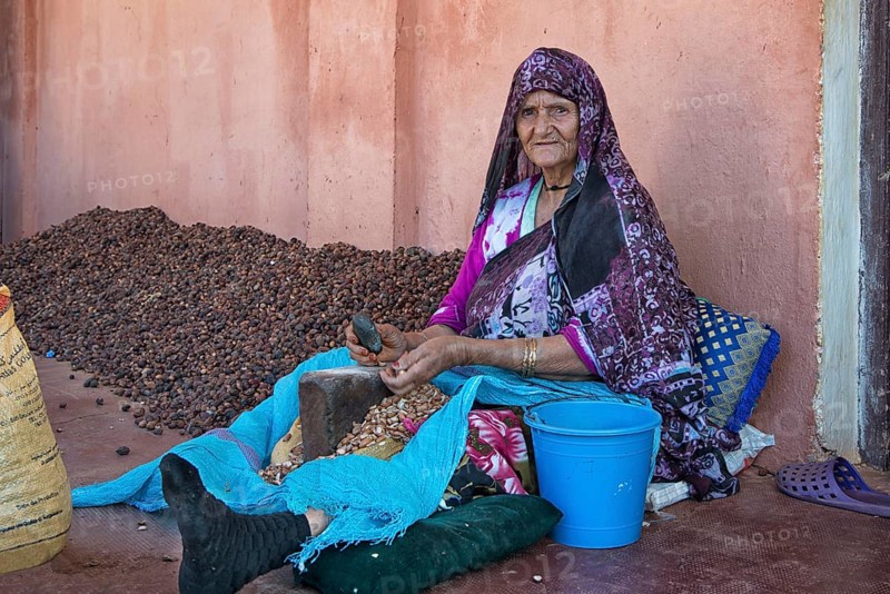 Woman tapping the hard kernels of the argan nut