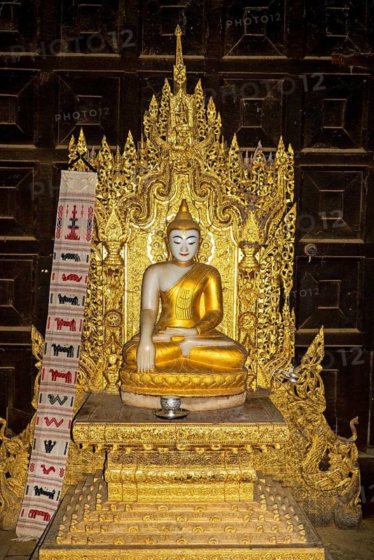 Buddha statue in teakwood monastery