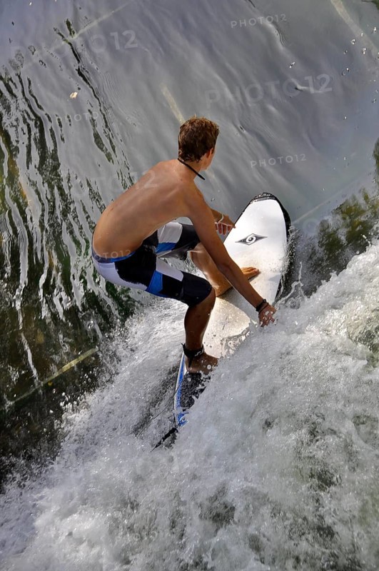 Standing surfer in the wave in the Eisbach at the Tierpark