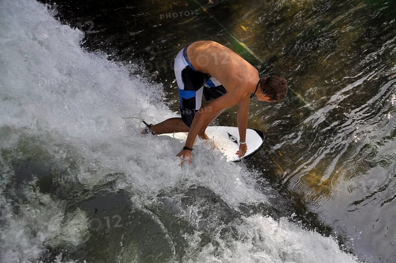 Standing surfer in the wave in the Eisbach at the Tierpark