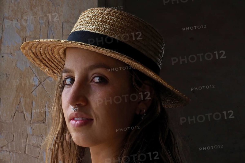 Young woman with straw hat and nose piercing