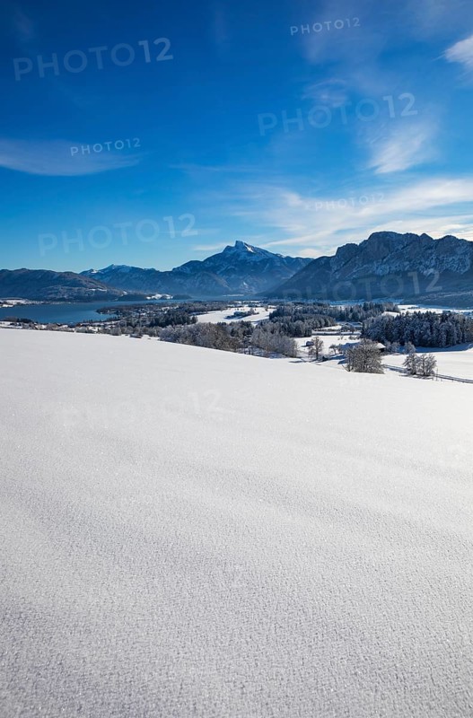 View of snow-covered Mondseeland with Schafberg and Drachenwand