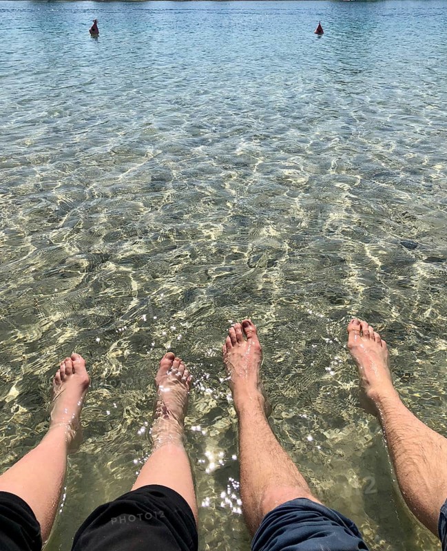 Two pairs of feet in the water