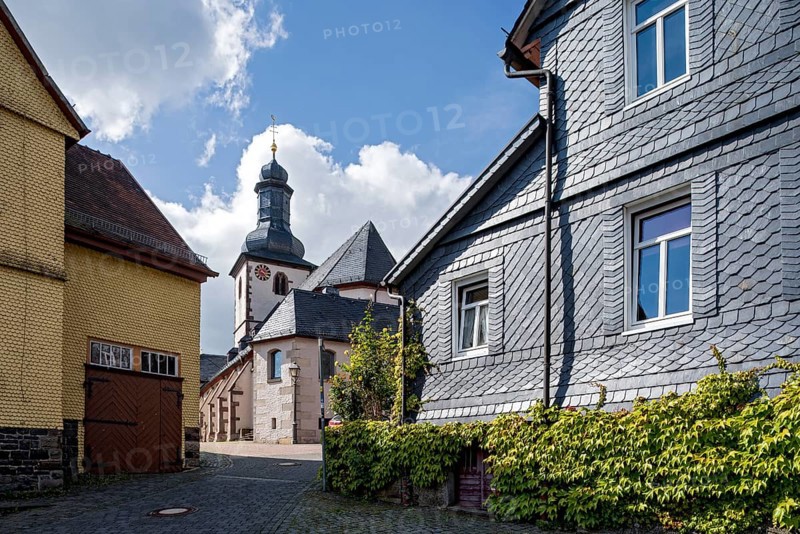 St. James Catholic Church among old clapboard houses made of wood and slate