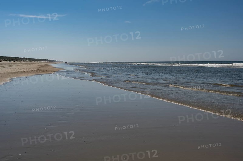 Long sandy beach with outgoing waves