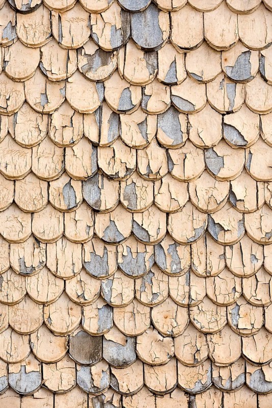 pattern of old wooden shingles with peeling paint