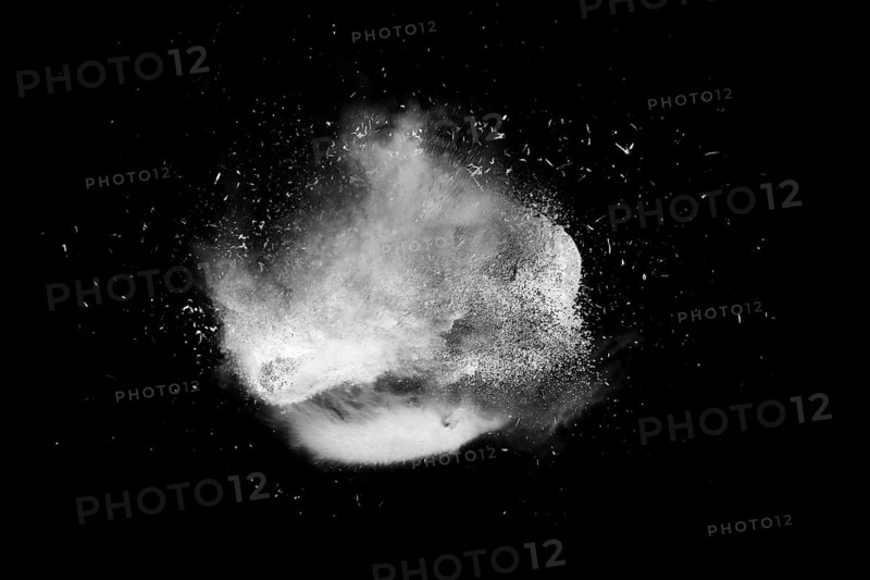Freeze motion of white powder paint exploding isolated on black