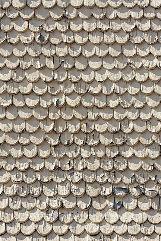 pattern of old wooden shingles with peeling paint