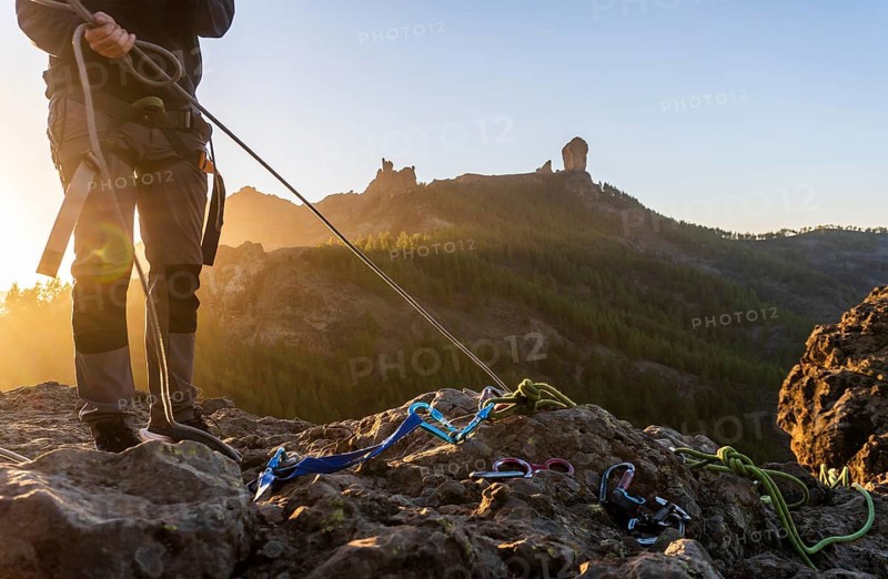 Man with professional gear doing rappelling sport in beautiful scenery of Roque Nublo mountain