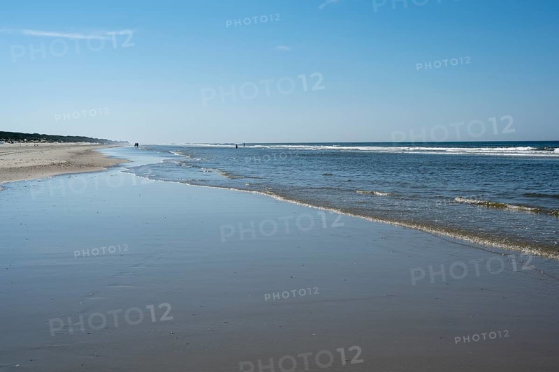 Long sandy beach with outgoing waves