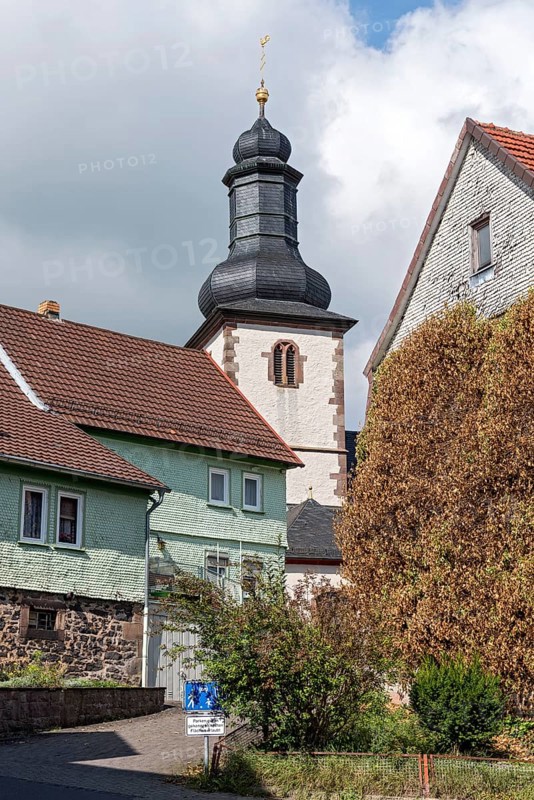 Bell tower of the Catholic Church of St. James between old clapboard houses