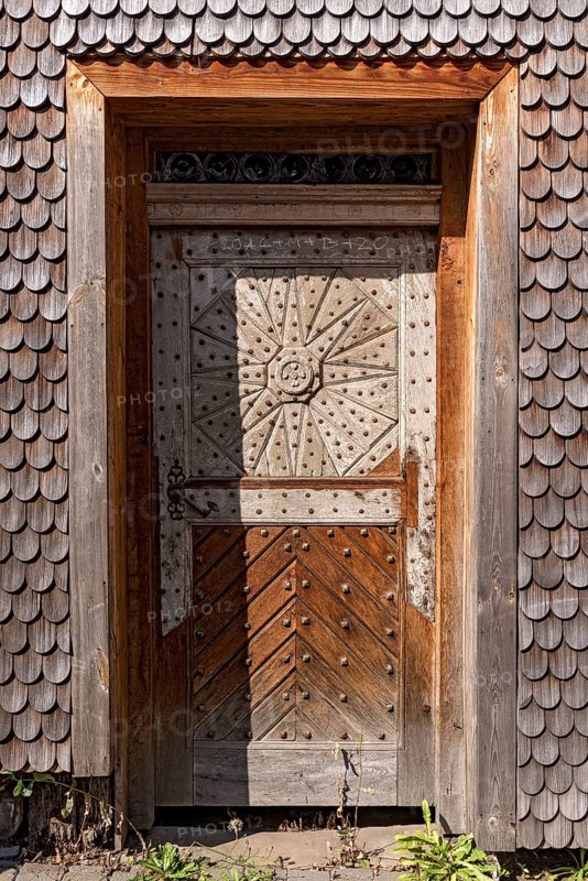 Old wooden door in dilapidated wooden clapboard house