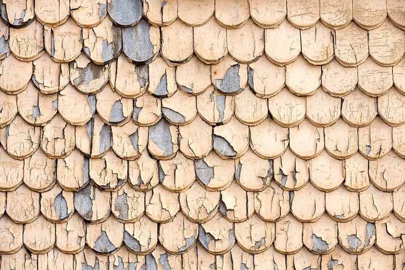 pattern of old wooden shingles with peeling paint