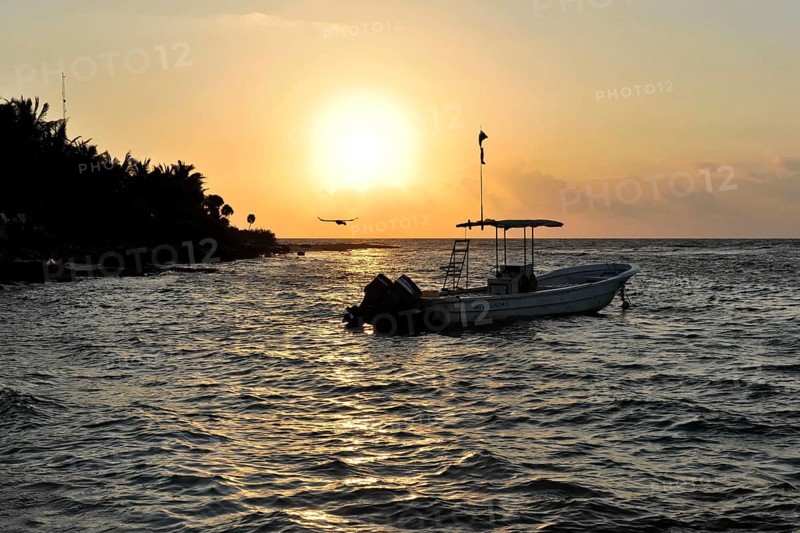 Sunset with boat at Playa del Carmen