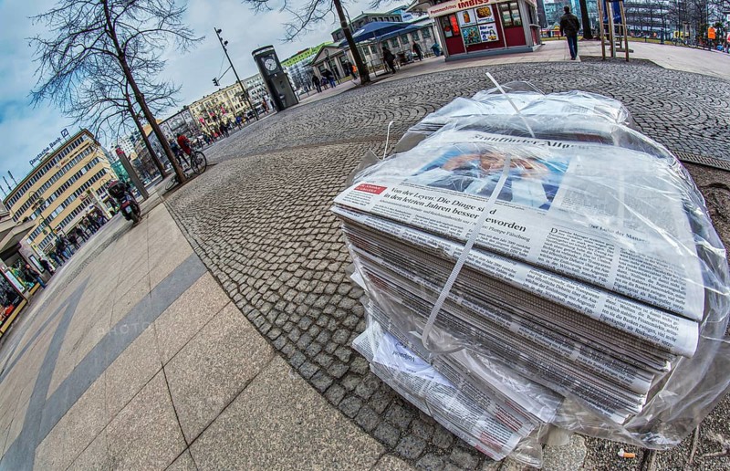 Piles of daily newspapers on the pavement