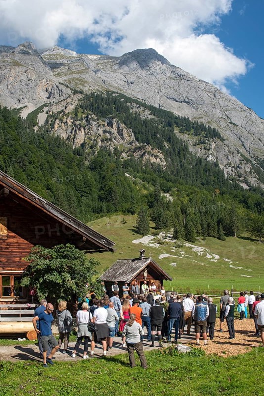 Mass celebration on Almkirtag in front of the wooden chapel in the mountain village of Eng