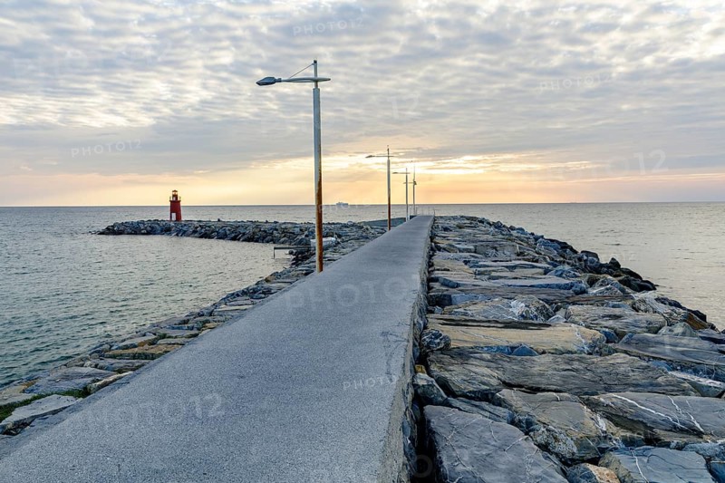 Sunrise with lighthouse at the harbour pier in Porto Maurizio