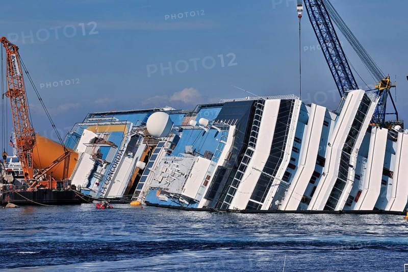 View of the upper deck of the capsized cruise ship with the name Costa Concordia visible