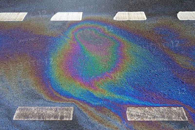 Environmentally harmful traces of oil on an asphalt road