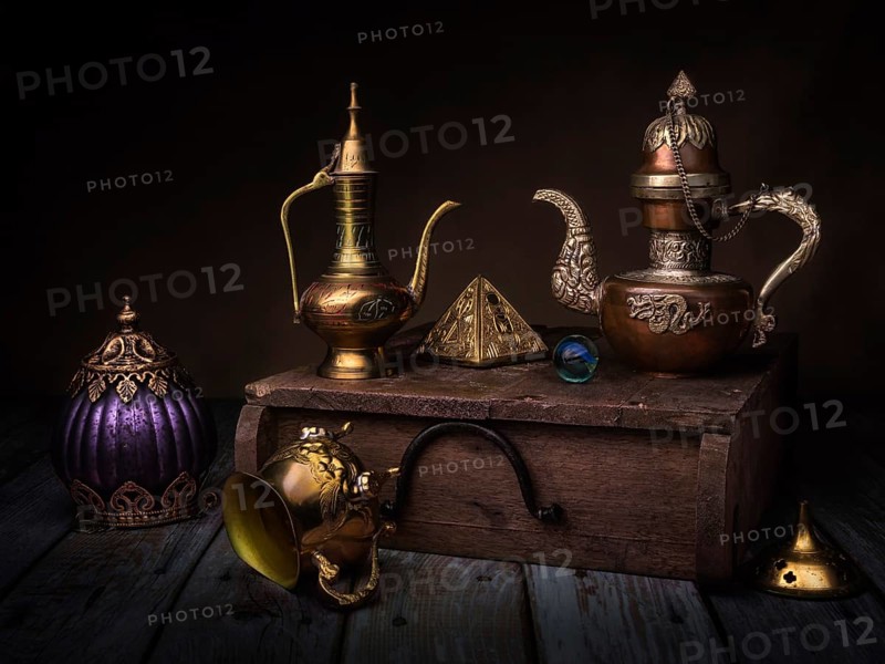 Still life with oriental jug and gilded pyramid on wooden box