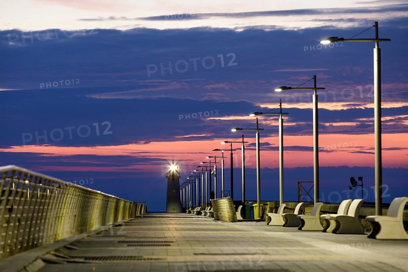 Sunrise with lighthouse at the harbour pier in Porto Maurizio