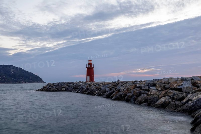 Sunrise with lighthouse at the harbour pier in Porto Maurizio
