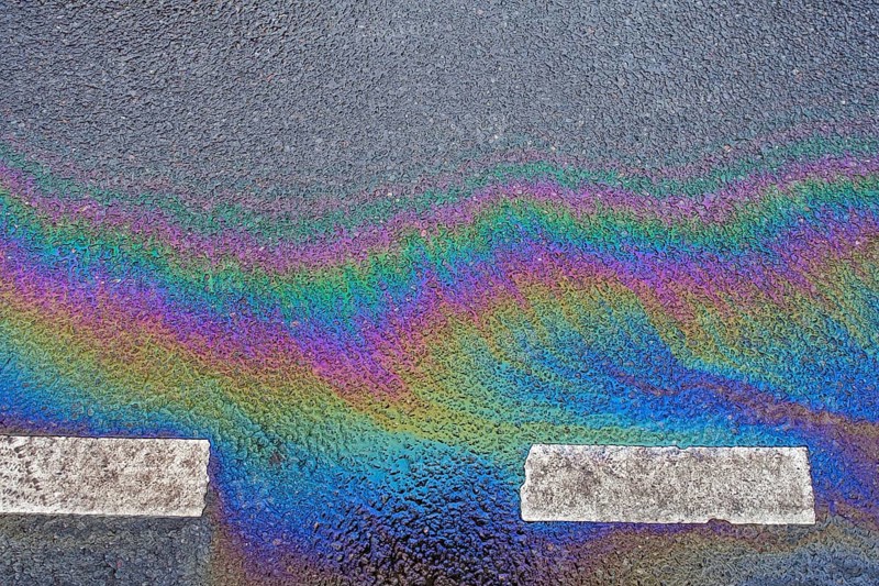 Environmentally harmful traces of oil on an asphalt road