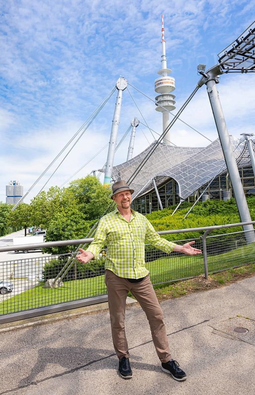 Friendly smiling man at the Olympic tower with Olympic tent roof