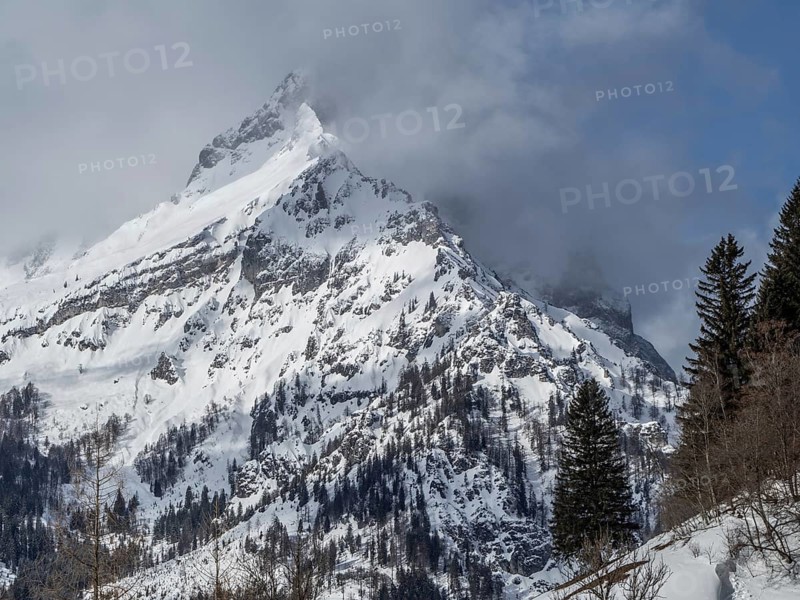 Snow-covered ridge in clouds