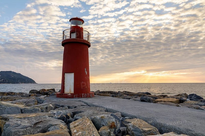 Sunrise with lighthouse at the harbour pier in Porto Maurizio