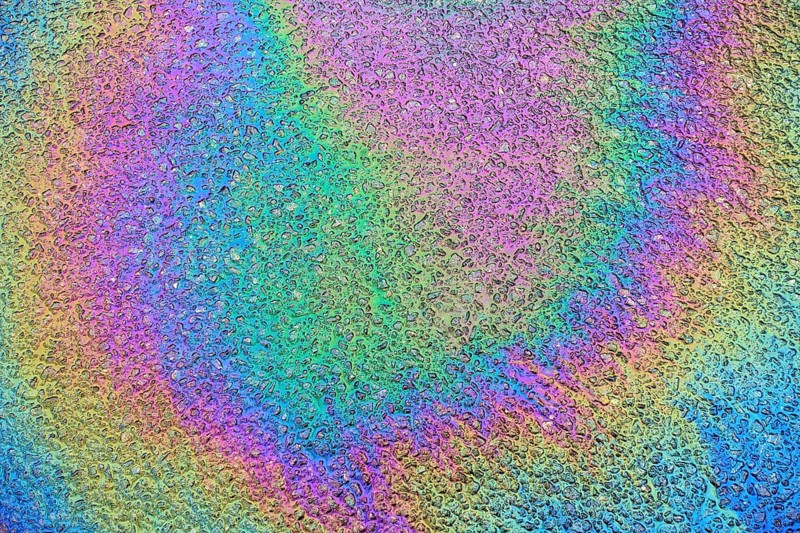Environmentally harmful traces of oil on an asphalt road