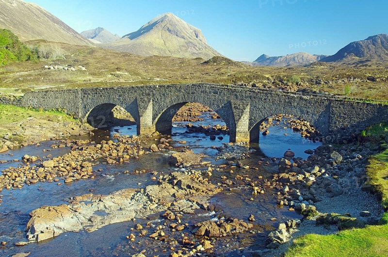 Old stone bridge leading over a stream