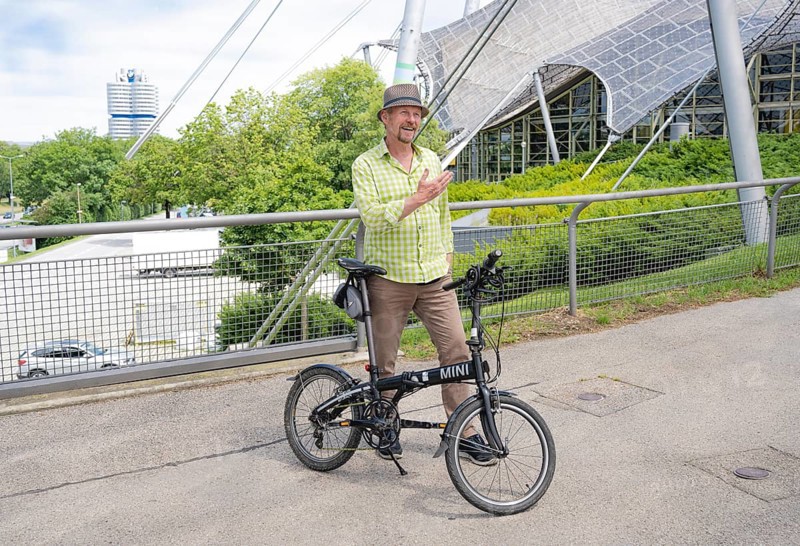 Man with bicycle on the Olympic tent roof