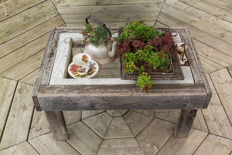 Rustic grey weathered wooden coffee table with old tea kettle