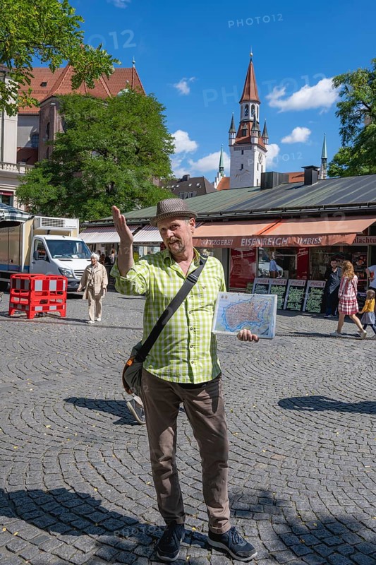 Tour guide with city map on city tour at the Viktualienmarkt