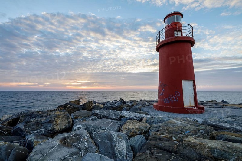 Sunrise with lighthouse at the harbour pier in Porto Maurizio