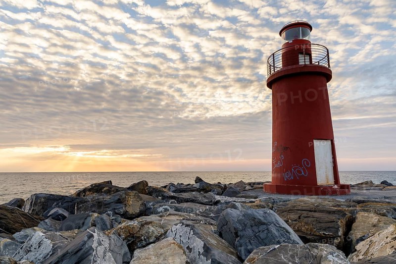 Sunrise with lighthouse at the harbour pier in Porto Maurizio