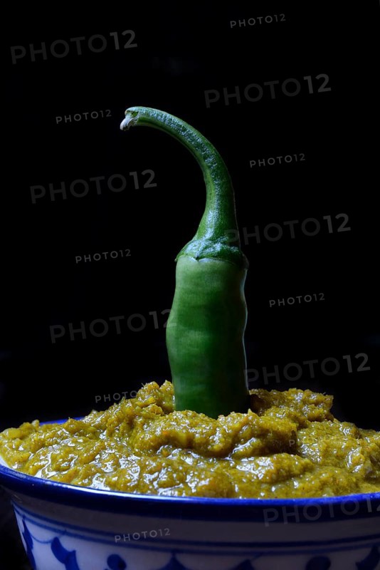 Green Thai curry paste in bowl with chilli pepper