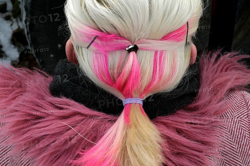 Blonde woman with pink hair and coat with pink fur collar