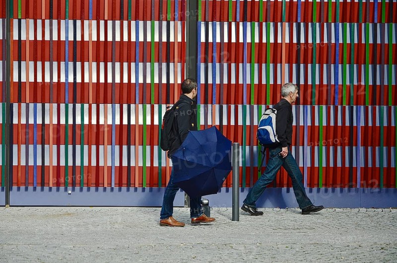 Two men walking in front of the colourful striped facade of the Museum Brandhorst
