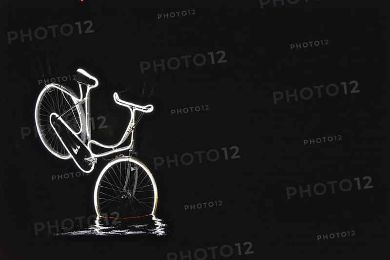 Neon-lit bicycle dives into the water of a canal
