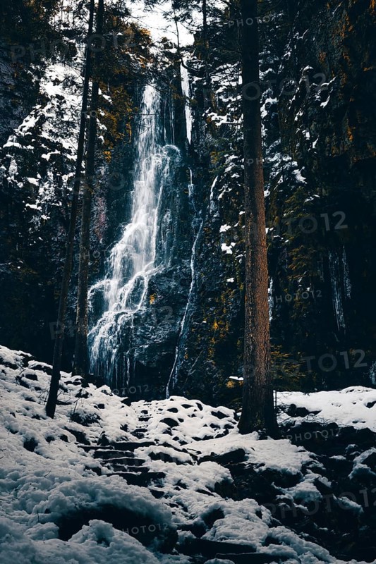 The Burgbach waterfall in winter with snow and ice