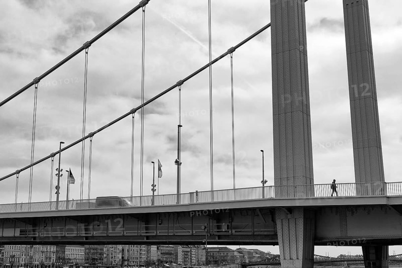 Pedestrian walking over steel suspension bridge