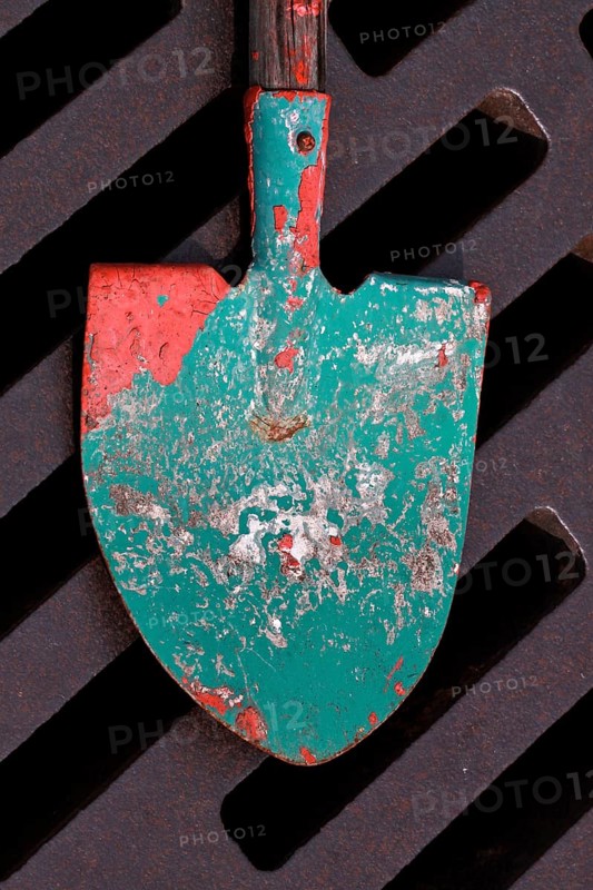 Shovel used to stir paint lies on drain grate of manhole