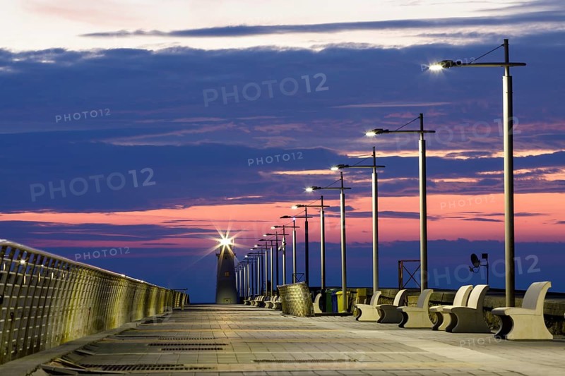 Sunrise with lighthouse at the harbour pier in Porto Maurizio