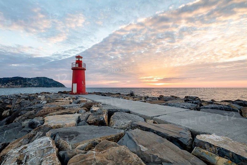 Sunrise with lighthouse at the harbour pier in Porto Maurizio