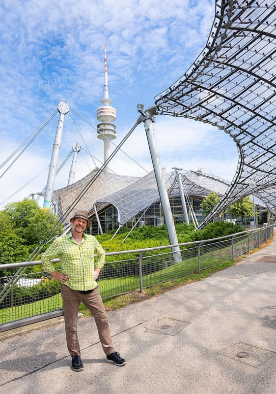 Friendly smiling man at the Olympic tower with Olympic tent roof