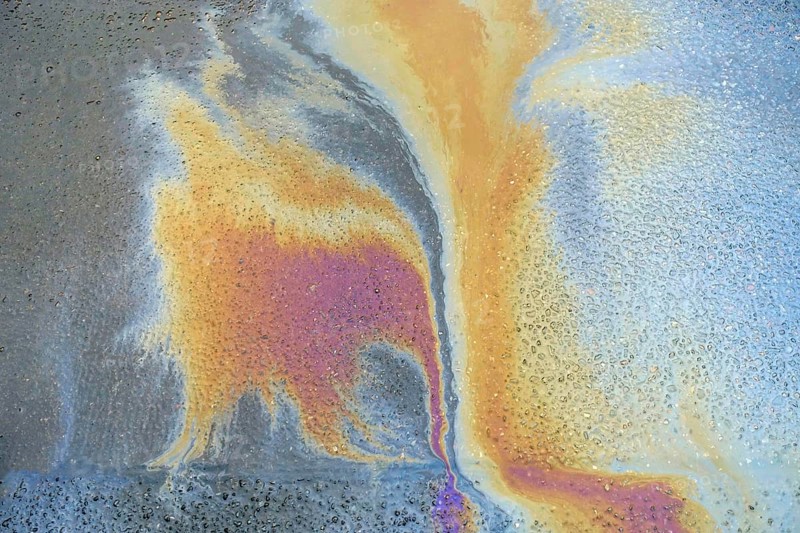 Environmentally harmful traces of oil on an asphalt road